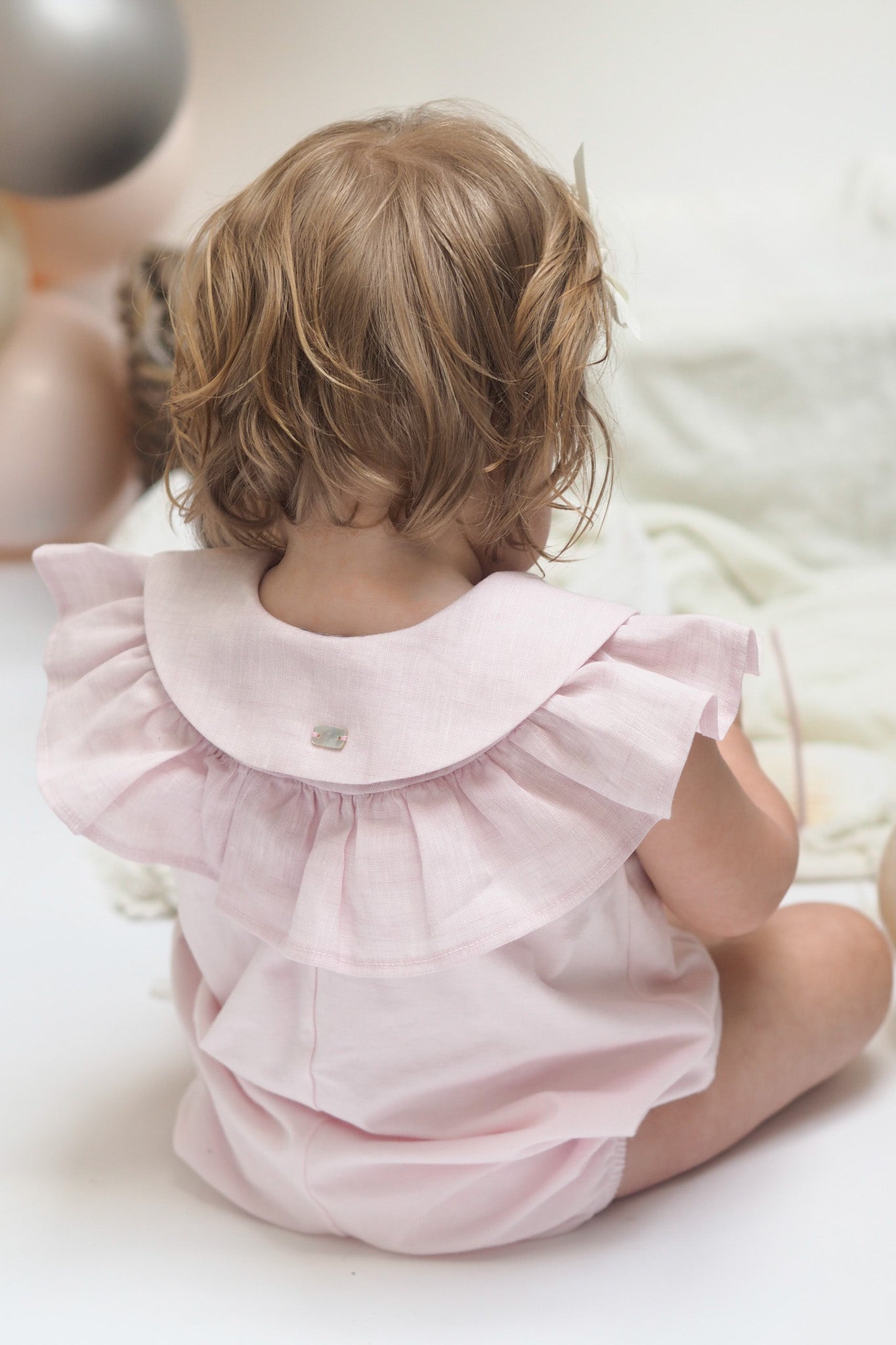 pink frilled romper back view