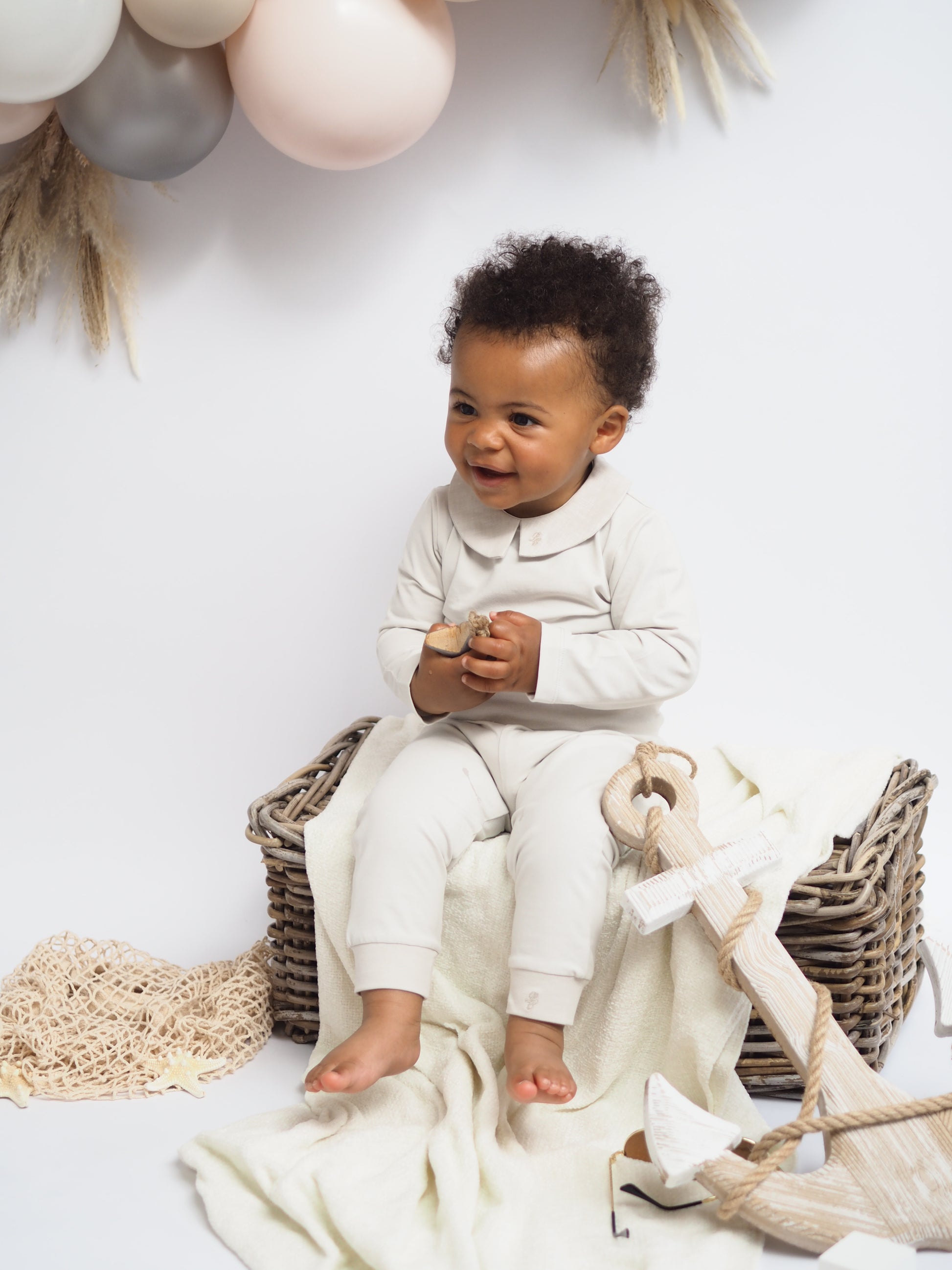 baby boy in bodysuit and leggings sat down